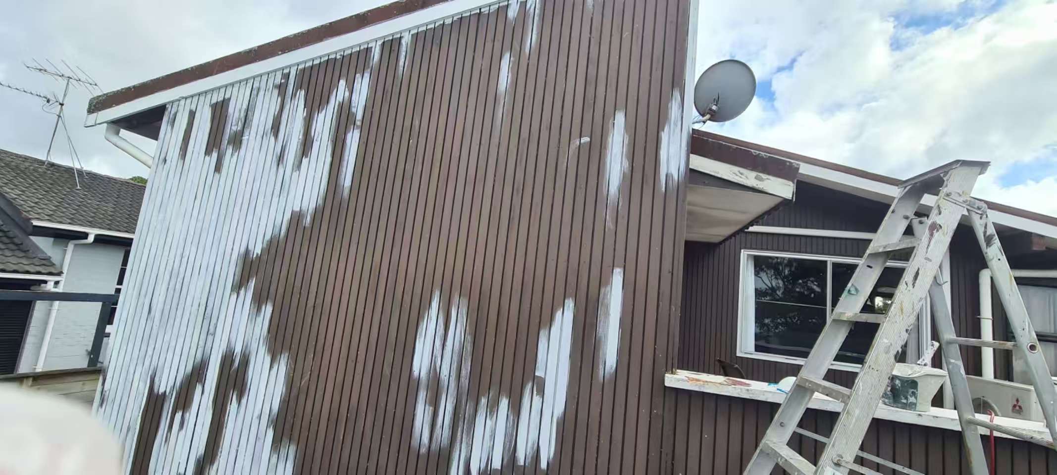 Weatherboard house exterior before repainting with patchy primer